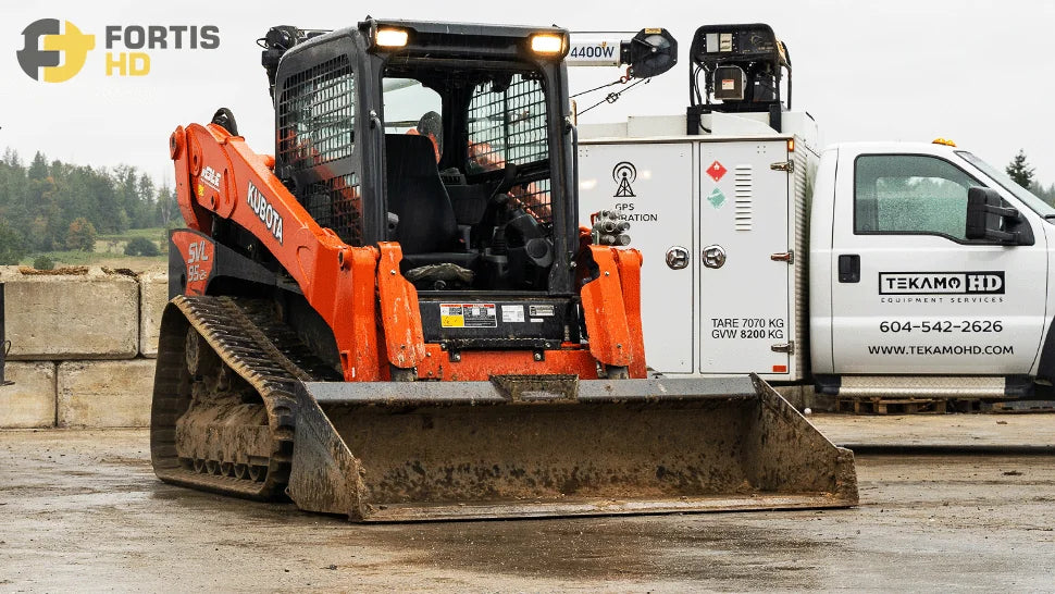 A Kubota SVL 95 skid steer loader is parked in front of a service truck
