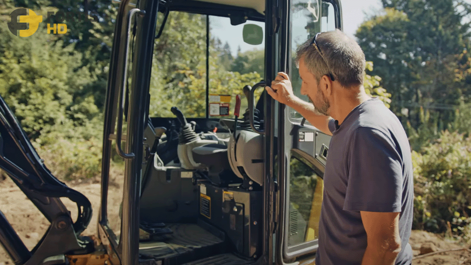 A guy looking inside the cab of a John Deere heavy equipment_