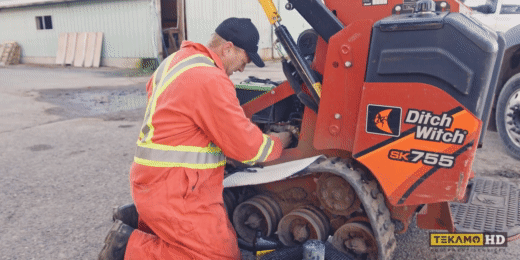 HD mechanic removing a hydraulic filter from the Ditch Witch mini skid steer
