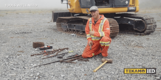 Tools needed to change the track on a large excavator laid out on the ground