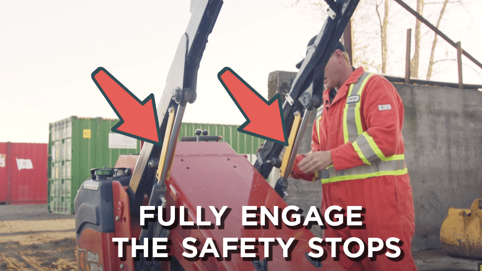 Arrows indicate what fully engaged safety stops should look like on a mini skid steer