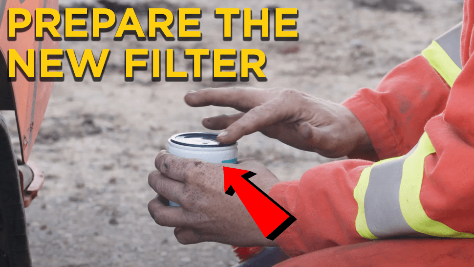 Heavy mechanic holding a spin-on fuel filter