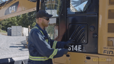 Heavy-duty mechanic shows the cabin air filter compartment on a Cat 314E.