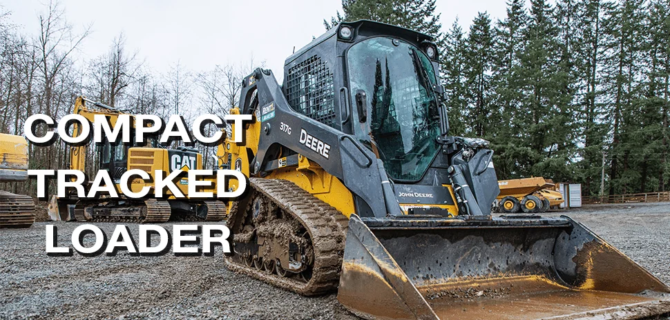 John Deere tracked loader parked with other heavy equipment