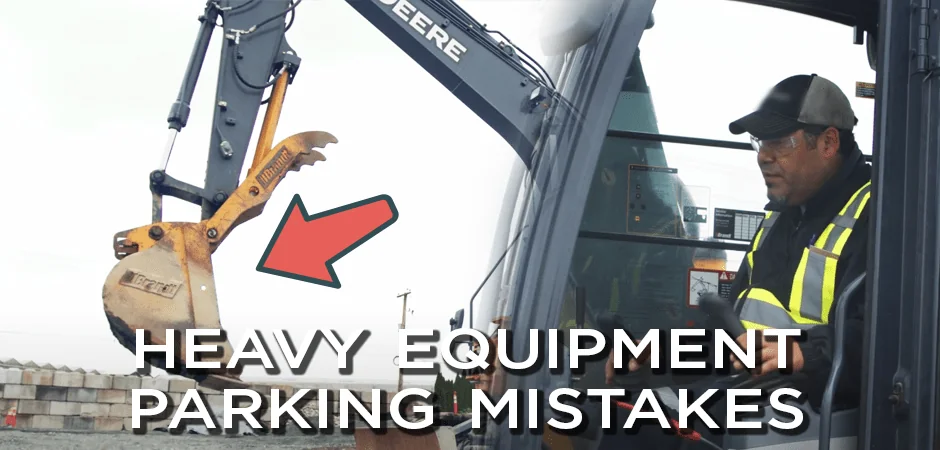 Arrow points to raised boom on a parked John Deere excavator