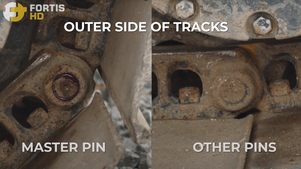Close-up of the outer side of steel tracks showing the master pin compared to a regular pin.
