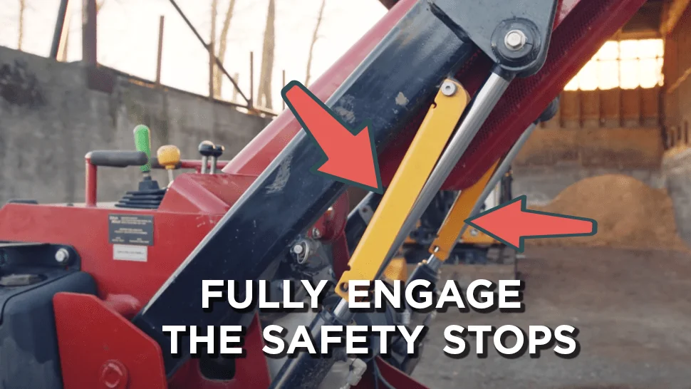 Pointing to engaged safety stops on a mini skid steer
