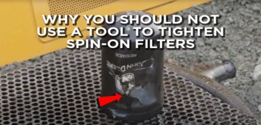 A crushed in spin-on oil filter with overlay text saying "Why You Should Not Use A Tool To Tighten Spin-On Filters"