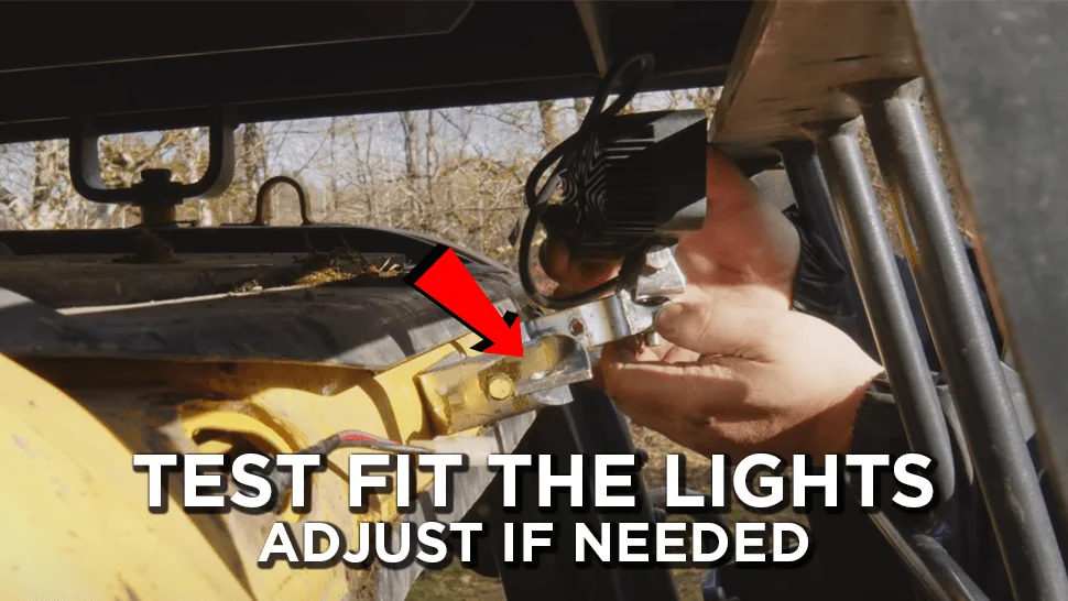 Red arrow pointing to mounting brackets where HD mechanic test fitting the lights