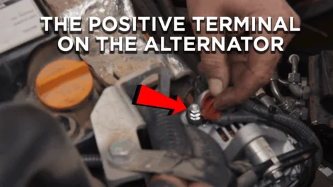 HD mechanic pointing out the positive terminal on the alternator of a John Deere 35G Mini Excavator