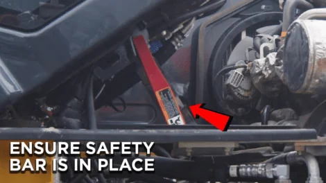 Red safety bar in the upright position on a John Deere Excavator