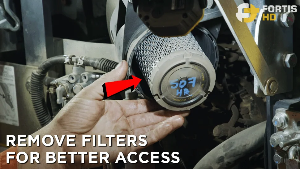 A heavy-duty mechanic takes the engine air filters off a John Deere 17G Mini Excavator.