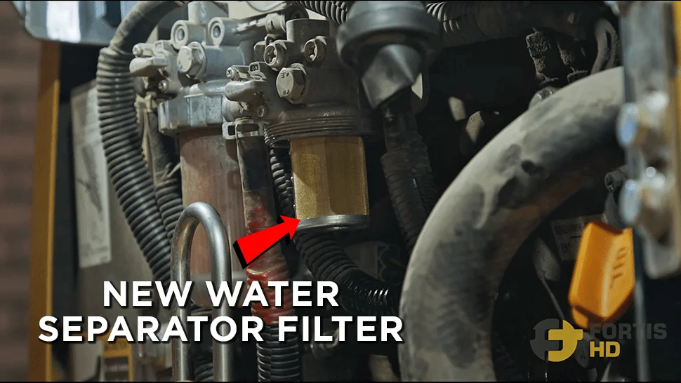 An arrow points at a new water separator filter on a John Deere 17G.