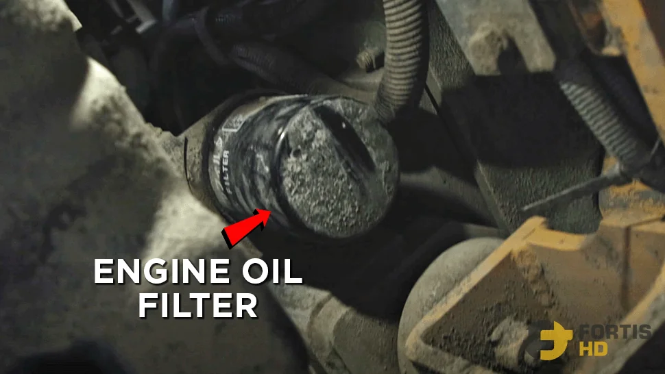An arrow pointing at the engine oil filter of a John Deere 85G Excavator.