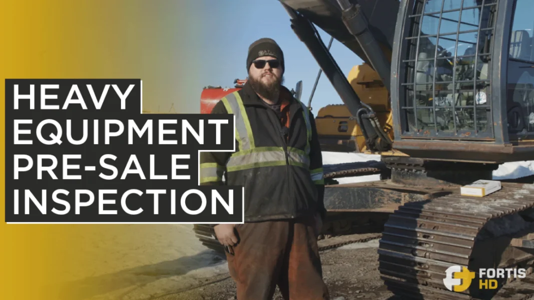 Heavy-duty mechanic does a pre-sale inspection on a used excavator.