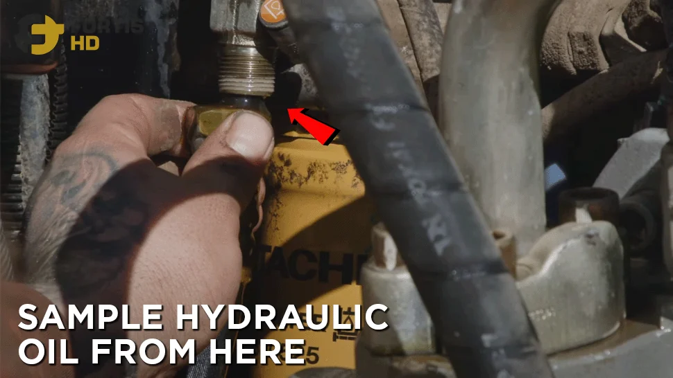 Heavy-duty mechanic pulls off an excavator’s hydraulic oil line.