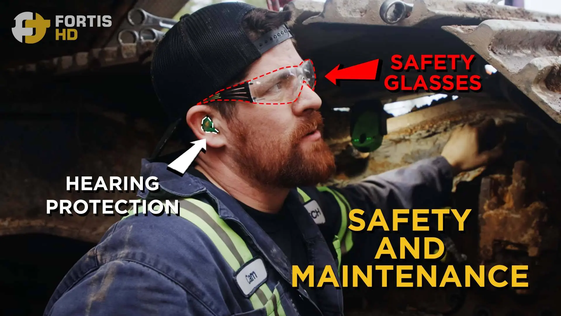 A heavy-duty mechanic wears safety glasses and hearing protection while working on a final drive.