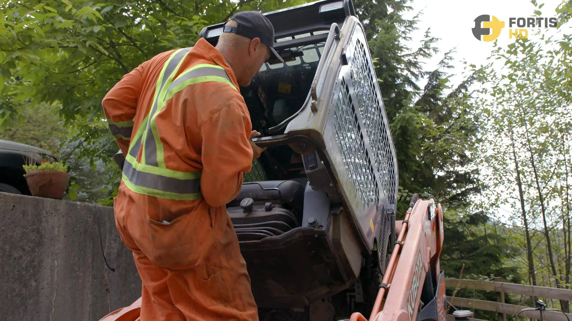 A heavy-duty operator flips up the cab of an SVL75-2.